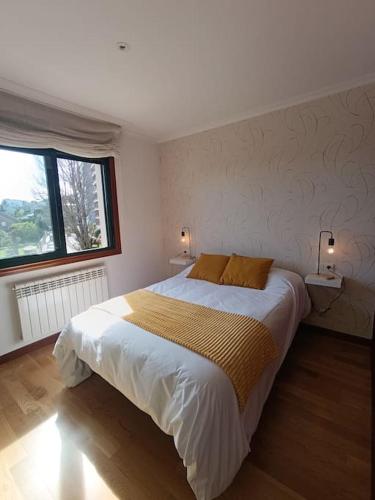 um quarto com uma cama grande e uma janela em Apartamento en Poio-Pontevedra em Poio