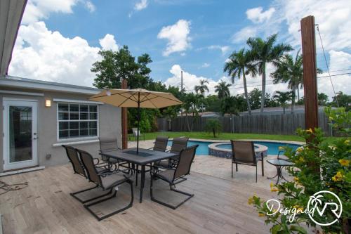 een patio met een tafel en stoelen en een zwembad bij Private Pool 3BR all new Modern Furniture in Hollywood