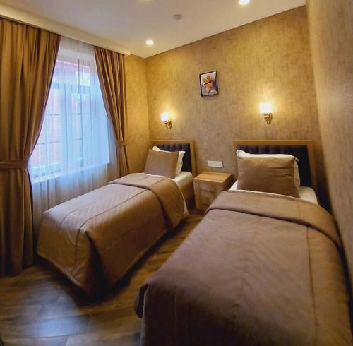 pokój hotelowy z 2 łóżkami i oknem w obiekcie Etci hotel & restaurant w mieście Qəbələ