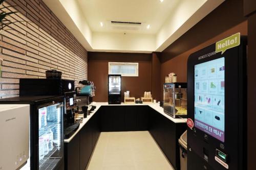 a coffee shop with a counter with a large screen at Hotel In Modern in Cheongju