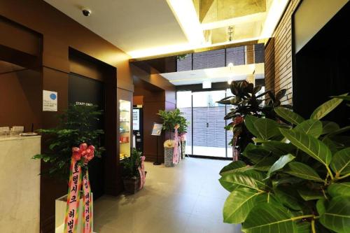 a lobby with potted plants in a building at Hotel In Modern in Cheongju
