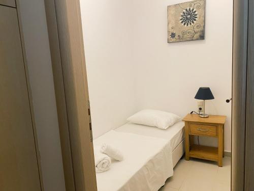 a small bedroom with a bed and a night stand at Lagada Resort in Makry Gialos