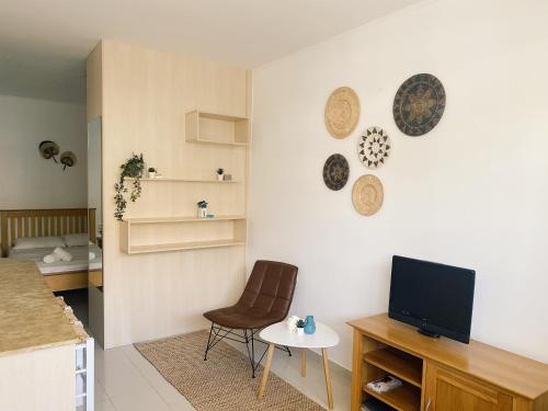 a living room with a tv and a table and a chair at Lagada Resort in Makry Gialos