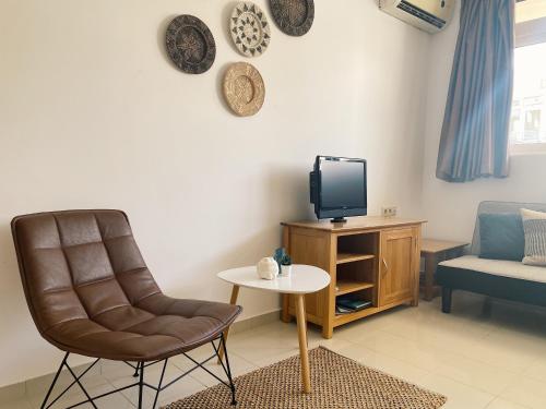 a living room with a chair and a tv at Lagada Resort in Makry Gialos