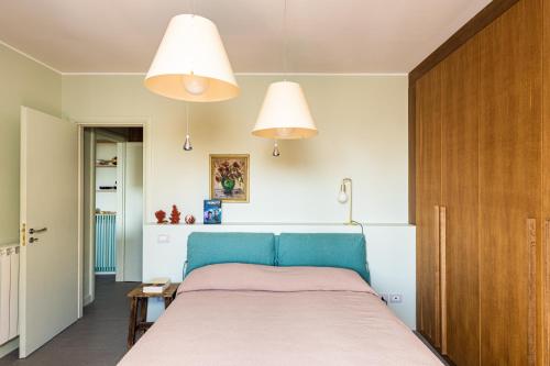 a bedroom with a blue bed and two lights at Olga's Apartment a Mondello by Wonderful Italy in Mondello