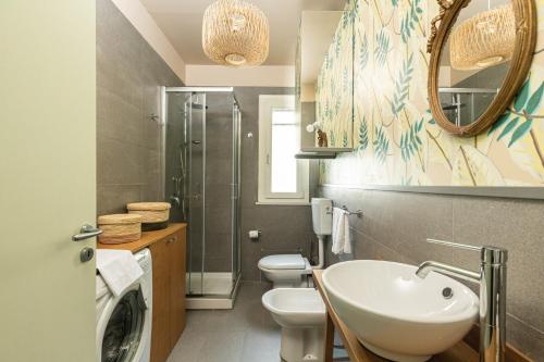 a bathroom with a sink and a toilet and a mirror at Olga's Apartment a Mondello by Wonderful Italy in Mondello