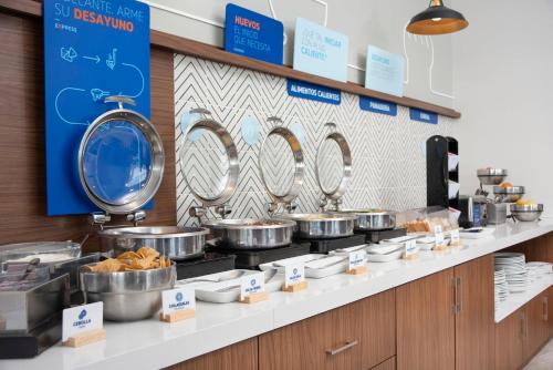 a buffet line with pots and pans and food at Holiday Inn Express Guadalajara Iteso by IHG in Guadalajara