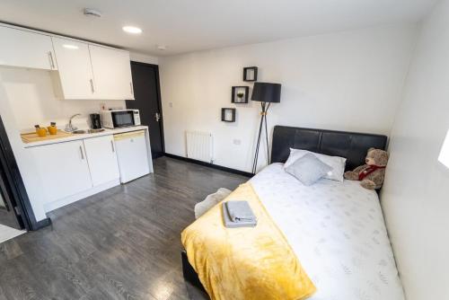 a small bedroom with a bed and a kitchen at STAY SA Cosy equipped studios available 10 mins from the city! Free WIFI &50" SMART TV's! in Birmingham