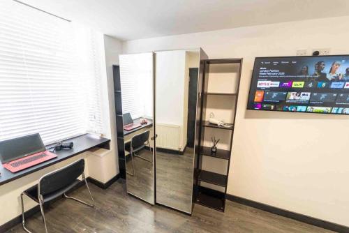 an office with a mirror and a laptop on a desk at STAY SA Cosy equipped studios available 10 mins from the city! Free WIFI &50" SMART TV's! in Birmingham