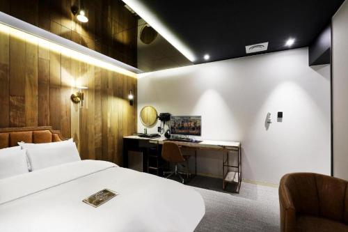 um quarto com uma cama branca e uma secretária em Hotel In Modern em Cheongju