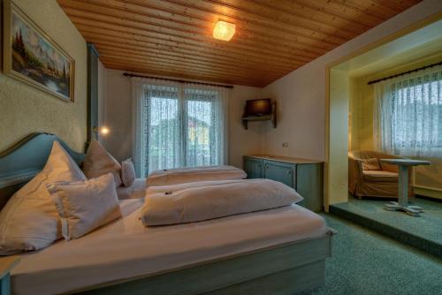 a bedroom with two beds and a wooden ceiling at Trail Hotel Oberstaufen in Oberstaufen