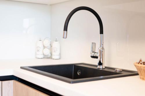 a black kitchen sink in a white kitchen at Pet Friendly Apartment Blue Ocean Umag in Umag