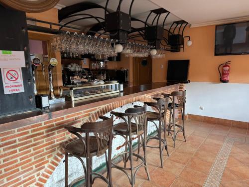 a bar with a row of bar stools at Hotel Pico Espiguete in Alba de los Cardaños