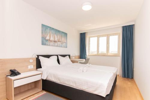 a bedroom with a large white bed and a window at Pet Friendly Apartment Blue Ocean Umag in Umag