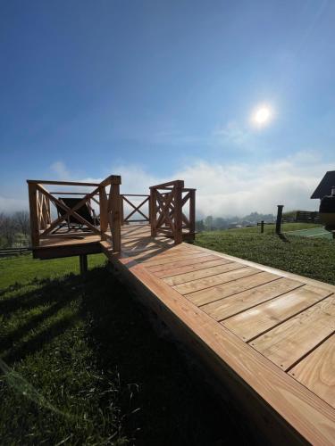 a wooden boardwalk in a field with the sky at Somnium Pieniny in Tylka