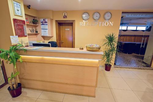 a reception counter in a waiting room with clocks on the wall at Supreme Victoria in Varna City