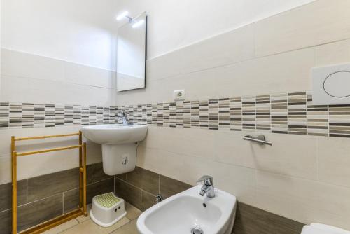 a bathroom with a sink and a toilet and a mirror at Cesarina Bilo in Procchio