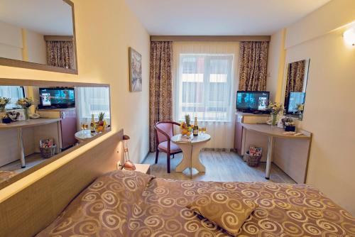 a hotel room with a bed and a desk at Supreme Victoria in Varna City