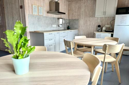 una cucina con 2 tavoli, sedie e frigorifero di Tamme staadioni hostel a Tartu