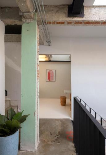 an empty room with a green wall and a staircase at Stupid Stay in Bangkok