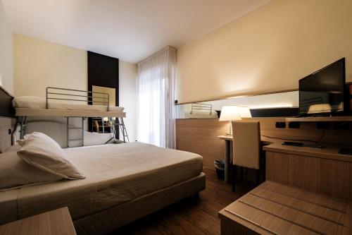 里乔内Augustus Hotel Riccione的配有双层床和书桌的酒店客房