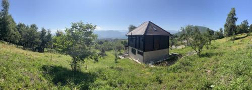een klein gebouw op een heuvel in een veld bij Lazarus house in Berane