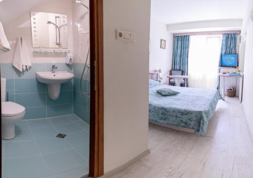 a bathroom with a shower and a bed and a sink at Supreme Victoria in Varna City