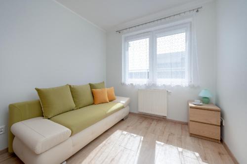 a living room with a couch and a window at Beautiful Apartment with a Spacious Balcony in Wrocław by Renters in Wrocław