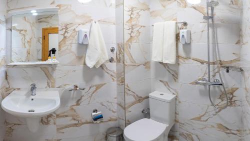 a bathroom with a toilet and a sink at Supreme Victoria in Varna City