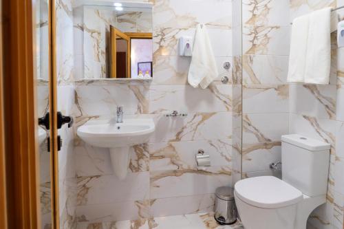 Baño blanco con lavabo y aseo en Supreme Victoria en Varna