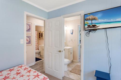 een kamer met een badkamer en een tv aan de muur bij 5001 Indebted By The Sea 3 Min Walk to Beach in Kill Devil Hills
