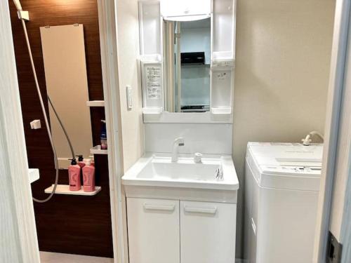 a small kitchen with a sink and a microwave at Nishi-Ike Apartment Room 3 in Tokyo