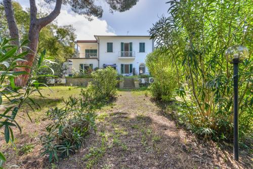 a white house in the middle of a garden at Cesarina Bilo in Procchio