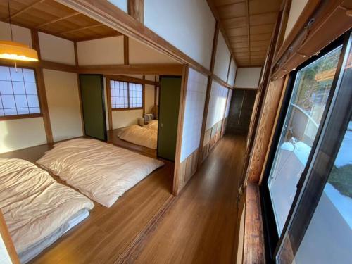 Zimmer mit 2 Betten und einem Fenster in der Unterkunft ゲスト専用プライベートサウナ付き一棟貸し宿 In Utero in Kashiwazaki