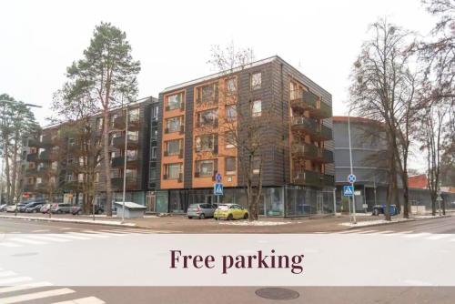 a building on a street with the words free parking at Cozy Center Druskininkai in Druskininkai