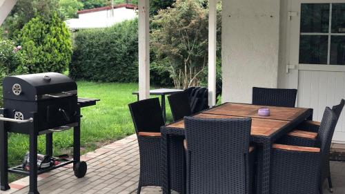 un patio con parrilla, mesa y sillas en Zimmer in Kyritz, en Kyritz