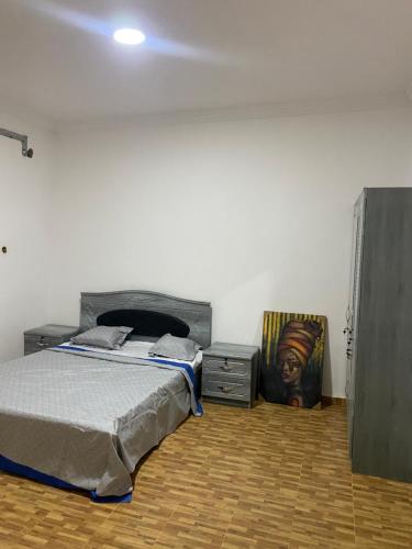 a bedroom with a bed and two night stands at Appartement Nouakchott in Nouakchott