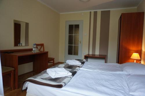 1 dormitorio con 1 cama con toallas en Geovita Lądek Zdrój, en Lądek-Zdrój