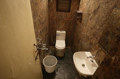 a small bathroom with a toilet and a sink at Hajiyar Residency in Rāmanāthapuram
