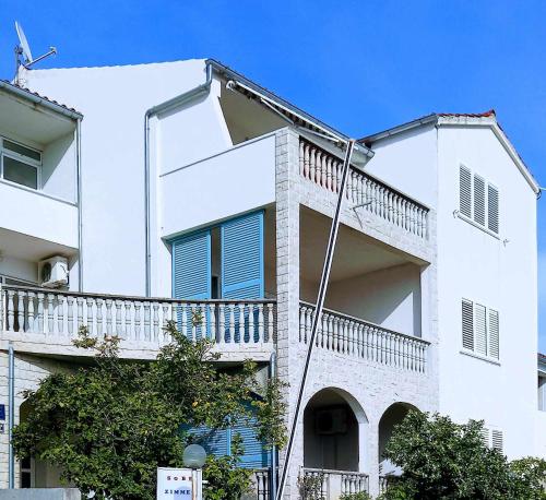 a white building with a balcony on the side of it at Apartmani Nina in Šibenik