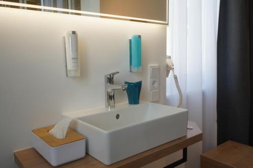 a bathroom with a sink and a phone on the wall at Eco Motel in Wallersdorf