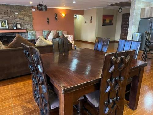 a wooden table and chairs in a living room at Harmony retreat in Nairobi
