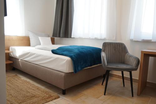 una camera con letto, sedia e finestra di Eco Motel a Wallersdorf