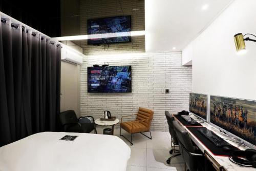 a room with a bed and a desk with chairs at Hotel In Modern in Cheongju