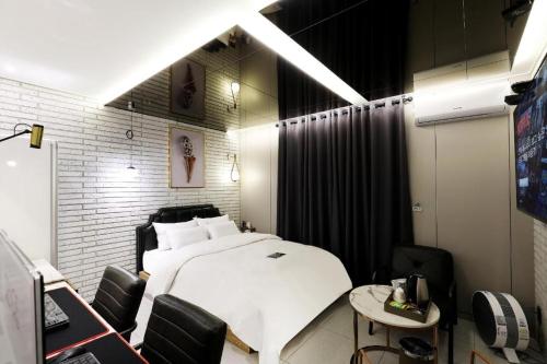 a bedroom with a bed and a table and chairs at Hotel In Modern in Cheongju