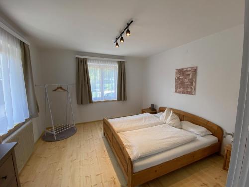 a bedroom with a bed in a room with a window at Almufer-Appartements in Grünau im Almtal
