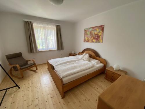 a bedroom with a bed and a desk and a chair at Almufer-Appartements in Grünau im Almtal