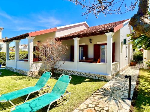 a pair of chairs in front of a house at Beachfront Suites GardenMare by DadoVillas in Litherés