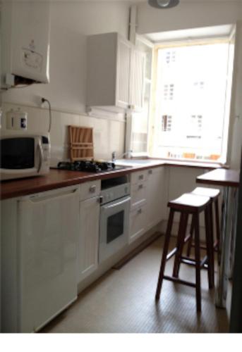 une cuisine avec des armoires blanches et un four à plaques de cuisson dans l'établissement Bel Appartement Intra Muros au coeur de SAINT MALO, à Saint-Malo