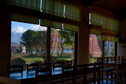 a dining room with a table and chairs and windows at HOTEL RESTORANT VIKTORIA in Gjirokastër